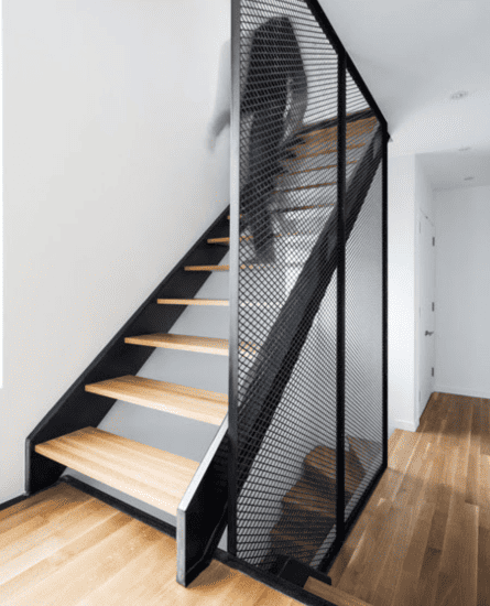 Escalier épuré en bois avec structure en métal et grille de protection noire, personnalisé par Abiver à Montpellier, combinant sécurité et style.