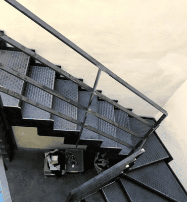 Escalier industriel en métal avec grille de protection, personnalisé par Abiver à Montpellier pour un espace commercial ou résidentiel.